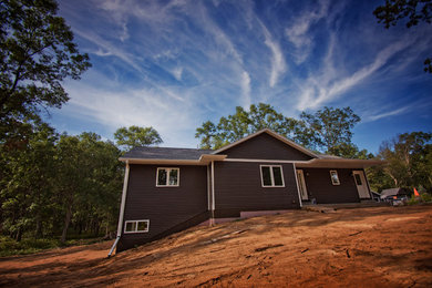 Example of a mid-sized mountain style gray one-story vinyl exterior home design in Other with a shingle roof