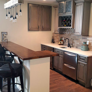 セントルイスの小さいトランジショナルスタイルのおしゃれな着席型バー (アンダーカウンターシンク、レイズドパネル扉のキャビネット、ヴィンテージ仕上げキャビネット、木材カウンター、マルチカラーのキッチンパネル、石タイルのキッチンパネル、無垢フローリング) の写真