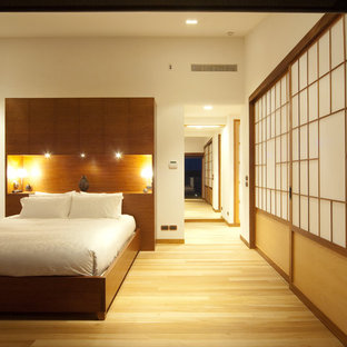 Ispirazione per una camera matrimoniale etnica con pareti bianche, parquet chiaro e pavimento beige