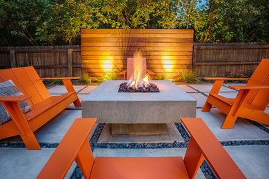 Photo of a mid-sized midcentury backyard patio in Denver with a fire feature and concrete pavers.