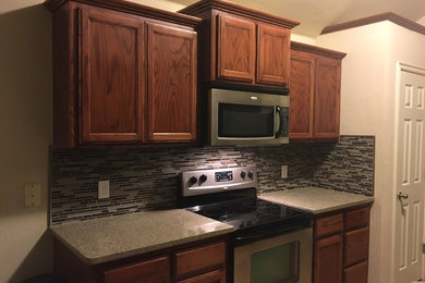 Photo of a mid-sized galley open plan kitchen in Oklahoma City with quartzite benchtops, multi-coloured splashback, mosaic tile splashback and with island.