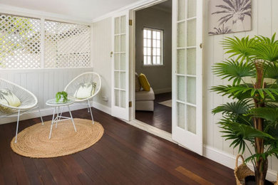 Small tropical front yard screened-in verandah in Brisbane with a roof extension.