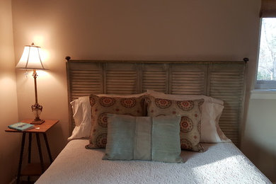 Modelo de dormitorio principal clásico de tamaño medio con paredes beige, suelo de madera en tonos medios y suelo marrón
