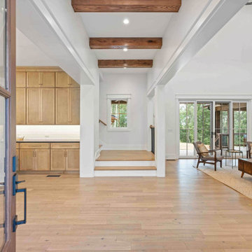 Grand Entryway to Modern Farmhouse: Open-Concept Flow with Exposed Beams and Hil