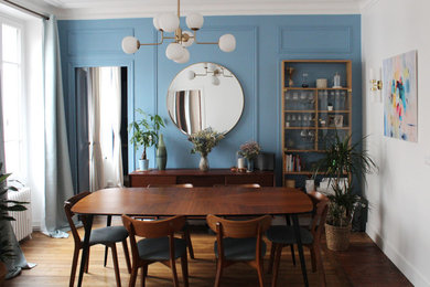 Idée de décoration pour une salle à manger bohème de taille moyenne avec un mur bleu, un sol en bois brun, aucune cheminée et un sol marron.