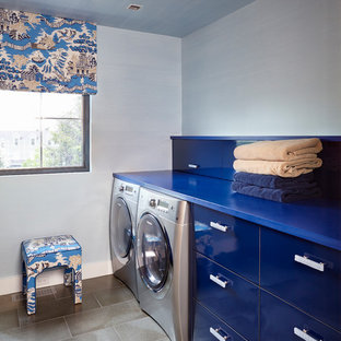 This is an example of an eclectic single-wall separated utility room in New York with flat-panel cabinets, blue cabinets, blue walls, a side by side washer and dryer and blue worktops.