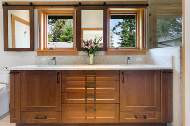 Inspiration for a mid-sized transitional master beige tile and porcelain tile porcelain tile, beige floor, double-sink and vaulted ceiling bathroom remodel in Seattle with recessed-panel cabinets, brown cabinets, a bidet, white walls, an undermount sink, quartz countertops, a hinged shower door, multicolored countertops and a built-in vanity
