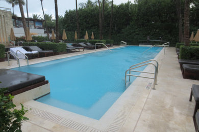 Design ideas for a medium sized back rectangular lengths swimming pool in Miami with a water slide and tiled flooring.