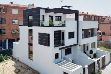 Imagen de fachada de casa blanca y negra actual de tamaño medio con revestimientos combinados, tejado plano y tejado de varios materiales