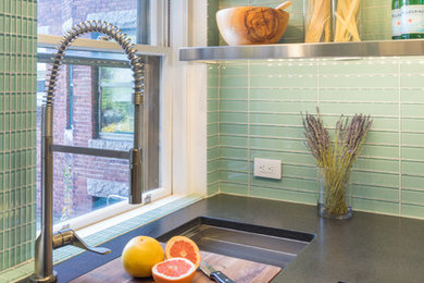 Eat-in kitchen - mid-sized contemporary u-shaped porcelain tile eat-in kitchen idea in Boston with an undermount sink, flat-panel cabinets, dark wood cabinets, granite countertops, green backsplash, glass tile backsplash, stainless steel appliances and a peninsula