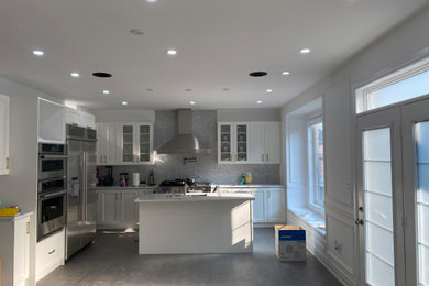 Example of a minimalist kitchen design in Toronto with stainless steel appliances and an island