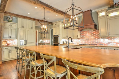 Dark wood floor kitchen photo in Atlanta with a farmhouse sink, raised-panel cabinets, concrete countertops, brick backsplash, stainless steel appliances and an island