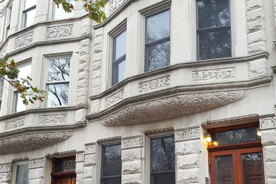 Design ideas for an expansive traditional three-storey grey townhouse exterior in New York with stone veneer.