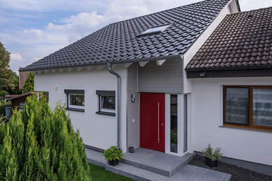 Photo of a contemporary two-storey white duplex exterior in Stuttgart with a gable roof and a tile roof.