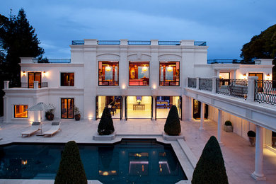 На фото: огромный, двухэтажный, белый дом в классическом стиле с облицовкой из бетона
