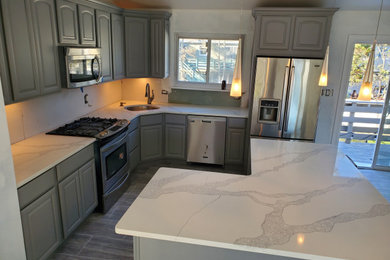 Inspiration for a mid-sized contemporary l-shaped ceramic tile and blue floor eat-in kitchen remodel in New York with an undermount sink, shaker cabinets, gray cabinets, quartz countertops, stainless steel appliances, an island and white countertops
