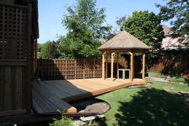 Photo of a mid-sized modern full sun backyard landscaping in Toronto with decking.