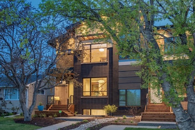Inspiration for a mid-sized 1960s beige two-story mixed siding duplex exterior remodel in Calgary with a shed roof and a shingle roof