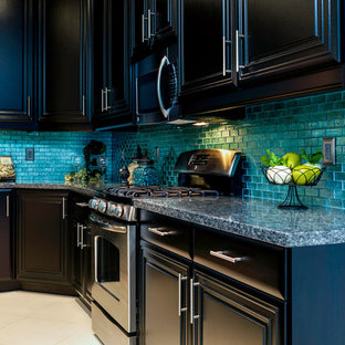 Mid-sized transitional kitchen pantry designs - Example of a mid-sized transitional l-shaped porcelain floor kitchen pantry design in Las Vegas with an undermount sink, raised-panel cabinets, black cabinets, granite countertops, blue backsplash, glass tile backsplash, stainless steel appliances and an island
