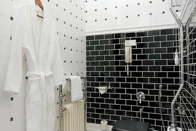 Traditional bathroom in Other with black tile and subway tile.