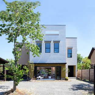 京都のモダンスタイルのおしゃれな家の外観 (レンガサイディング、片流れ屋根、戸建、金属屋根) の写真