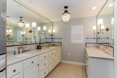 Example of a large transitional master multicolored tile porcelain tile and beige floor double shower design in Houston with raised-panel cabinets, white cabinets, gray walls, an undermount sink, quartz countertops and a hinged shower door