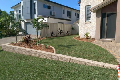 Design ideas for a tropical front yard full sun garden in Brisbane with mulch.