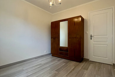 ナントにある中くらいなトラディショナルスタイルのおしゃれな客用寝室 (ベージュの壁、ラミネートの床、暖炉なし、グレーの床)
