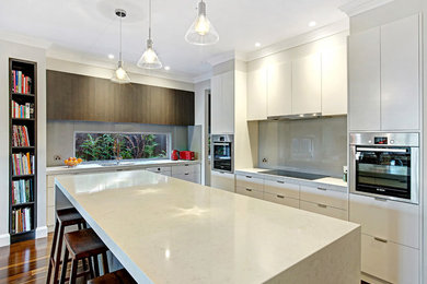 Modern kitchen in Melbourne with a double-bowl sink, solid surface benchtops, grey splashback, glass sheet splashback, stainless steel appliances, dark hardwood floors and with island.