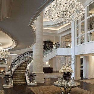 Выдающиеся фото от архитекторов и дизайнеров интерьера: огромное фойе в классическом стиле с белыми стенами и темным паркетным полом