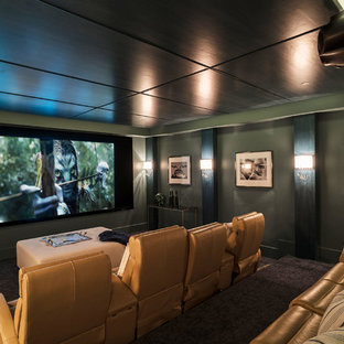 Idée de décoration pour une grande salle de cinéma marine fermée avec moquette, un écran de projection, un mur vert et un sol marron.