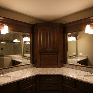 Ispirazione per una grande stanza da bagno padronale minimalista con ante con bugna sagomata, ante in legno bruno, doccia ad angolo, piastrelle grigie, piastrelle di ciottoli, pareti beige, top in granito e lavabo sottopiano