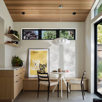 Modern ADU Breakfast Nook with Built-In Oak Bench and Yellow Art Accent