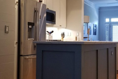 Small minimalist galley eat-in kitchen photo in Atlanta with shaker cabinets, white cabinets, marble countertops, gray backsplash, wood backsplash, stainless steel appliances, an island and white countertops