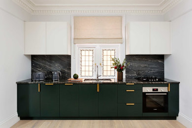 Photo of a medium sized contemporary open plan kitchen in London with granite worktops and granite splashback.