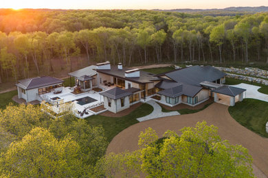 Inspiration for a large contemporary brown one-story wood and board and batten house exterior remodel in Nashville with a shed roof, a metal roof and a brown roof
