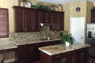 Eat-in kitchen - large traditional u-shaped dark wood floor and brown floor eat-in kitchen idea in Tampa with an undermount sink, granite countertops, stone slab backsplash, recessed-panel cabinets, dark wood cabinets, multicolored backsplash, stainless steel appliances and an island