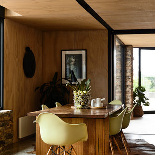 Contemporary dining room in Melbourne with beige walls, concrete floors and grey floor.