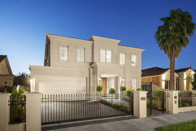 This is an example of a mid-sized traditional two-storey stucco beige exterior in Melbourne with a hip roof.