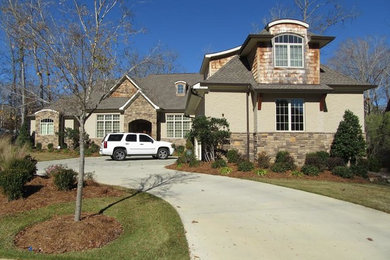 Inspiration for a mid-sized contemporary beige two-story stone exterior home remodel in Atlanta with a hip roof