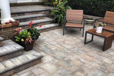 Inspiration for a mid-sized contemporary front yard patio in DC Metro with a container garden, brick pavers and a roof extension.