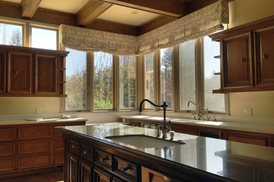 Photo of a large traditional l-shaped eat-in kitchen in San Francisco with an undermount sink, raised-panel cabinets, medium wood cabinets, granite benchtops, stainless steel appliances, medium hardwood floors and with island.
