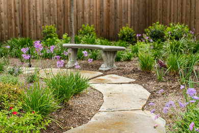 Large traditional backyard partial sun garden in Dallas with a garden path and natural stone pavers.