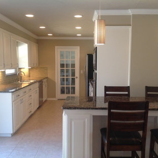 Mid-sized traditional kitchen pantry designs - Mid-sized elegant galley ceramic floor kitchen pantry photo in Oklahoma City with a drop-in sink, recessed-panel cabinets, white cabinets, granite countertops, beige backsplash, glass tile backsplash, stainless steel appliances and an island