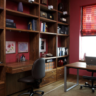 Contemporary home office in New York with a built-in desk and red walls.