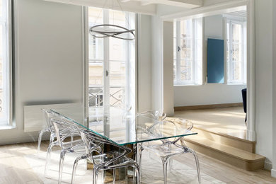 Exemple d'une grande salle à manger ouverte sur le salon avec un mur blanc, un sol en bois brun, aucune cheminée et un sol marron.
