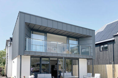 Imagen de fachada de casa multicolor y gris actual de tamaño medio de tres plantas con revestimiento de metal, tejado plano y tejado de metal