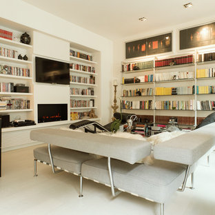 Modern inredning av ett mellanstort separat vardagsrum, med ett bibliotek, vita väggar, en bred öppen spis, en spiselkrans i gips, en väggmonterad TV, vitt golv och målat trägolv
