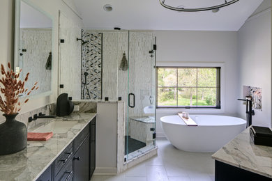 Inspiration for a large transitional master black and white tile and ceramic tile ceramic tile, gray floor, double-sink and vaulted ceiling bathroom remodel in Chicago with flat-panel cabinets, black cabinets, a one-piece toilet, white walls, an undermount sink, quartzite countertops, a hinged shower door, beige countertops and a built-in vanity