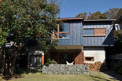 This is an example of a modern two-storey house exterior in Other with metal siding, a gable roof and a metal roof.